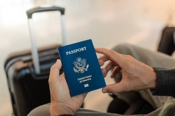 Traveler holding USA passport at the airport.| passport renewal timeline